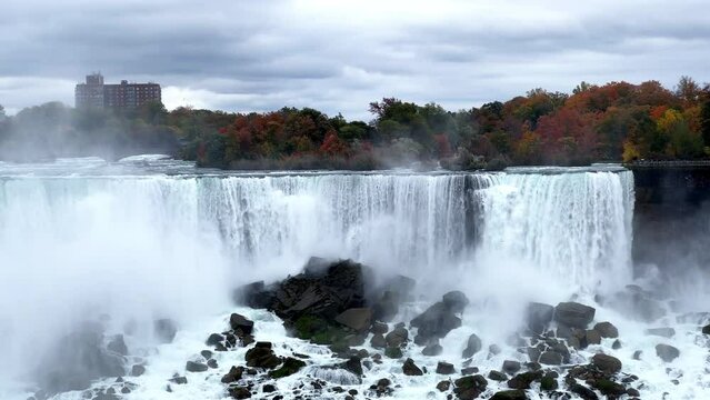 Full-flowing Niagara Falls in the fall. Mesmerizing view of the falling water. The strength and power of nature. American Niagara Falls. Close-up of Fata Waterfall.