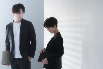 Smiling businesswoman and businessman with a computer having a meeting