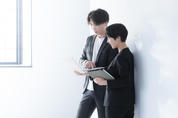 パソコンを持った笑顔のビジネスウーマンとビジネスマン