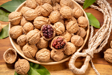 Red Walnuts in wooden bowl on wooden background, Walnuts kernels in wooden basket on wooden table.