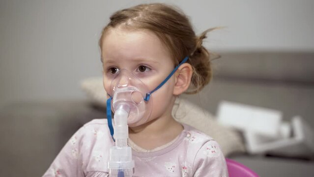 Closeup , little girl inhaling mist from nebulizer, closeup shot 