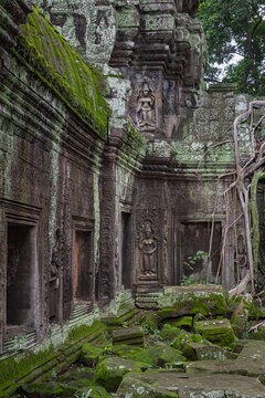 Stone wall temple ruin building architecture and moss covered rocks and bricks in Ta Prohm Tomb Raider Angkor Wat historical site in Seim Reap Cambodia on a cloudy overcast day