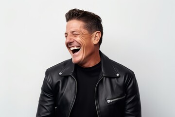 Obraz na płótnie Canvas Portrait of a handsome man laughing in leather jacket on white background