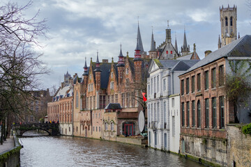 Beautiful city skyline of the village building architecture along a rozenhoedkaai Rosary Quay river canal reflection in Brugge Flanders Belgium on a cloudy day