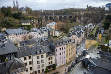 Colorful pink, yellow, and grey buildings in the old medieval town village along a walled cliff of Luxembourg City Europe