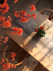 Morning Serenity: A Quiet Corner with Blooming Flowers,Wooden chair with flowers on table in cafe