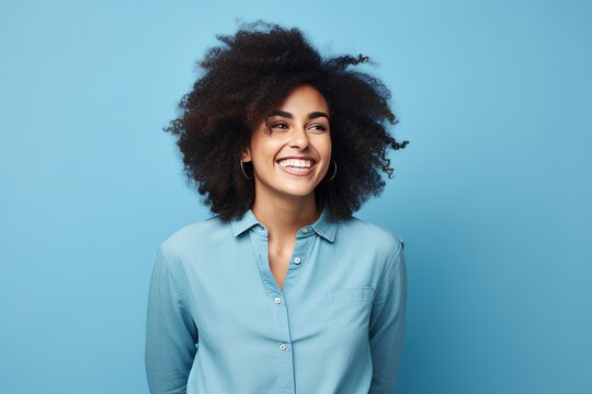 Portrait Of Smiling African American Woman In Blue Shirt On Blue Background