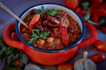 hearty homemade soup in the red bowl on the table