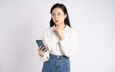 Fototapeta premium Portrait of young Asian businesswoman using phone on white background