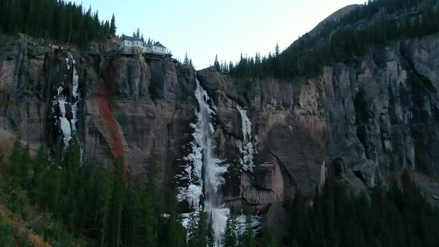 Bridal Veil Falls Telluride Colorado aerial drone frozen ice waterfall autumn sunset cool shaded Rocky Mountains Silverton Ouray Millon Dollar Highway historic town landscape slow upward jib motion