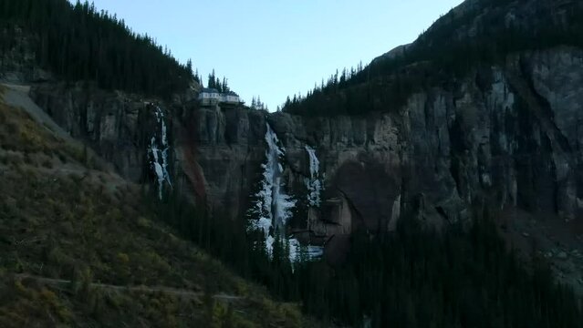 Telluride Colorado aerial drone  Bridal Veil Falls frozen ice waterfall autumn sunset cool shaded Rocky Mountains Silverton Ouray Millon Dollar Highway historic town scenic landscape parallax zoom
