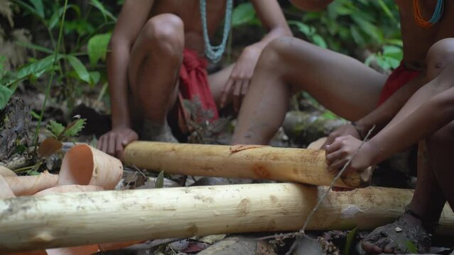 Members of the Mentawai Tribe in Indonesia make the material they use to create their loincloths. They are beating tree bark with a wooden tool to make it soft enough to make clothing.