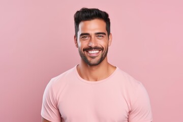 Portrait of handsome young man in pink t-shirt. Isolated on pink background