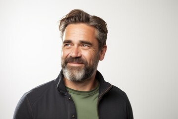 Portrait of a handsome mature man with beard and mustache smiling at the camera.