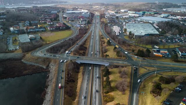 Hyperlapse shot of traffic on highway and crossing train on bridge in Dartmouth, Canada, Nova Scotia. Aerial view of the intersection and expressway during the day at the highway-prospect junction 