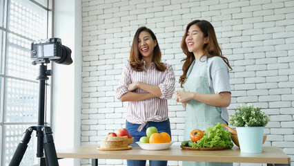 Asian influencer vlogger live review healthy eating lifestyle. Two Young woman friends blogger vlog happy lifestyle how to eating vegetables, fruit, vegan products. Two women talk social media vlog