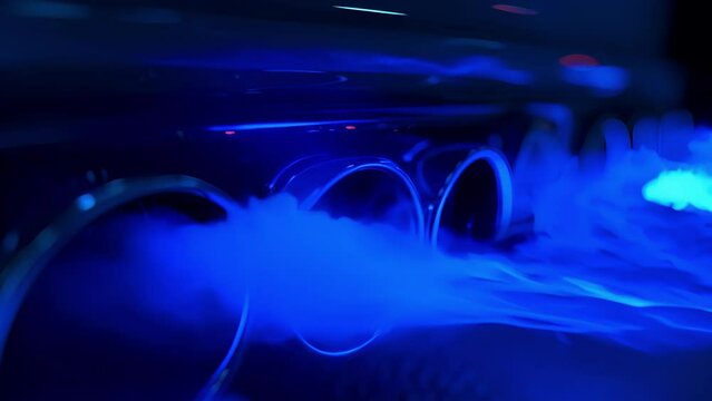 A slowmotion shot of a supercars exhaust pipes with thin yet bright blue flames flickering and dancing with each shift of the gears.
