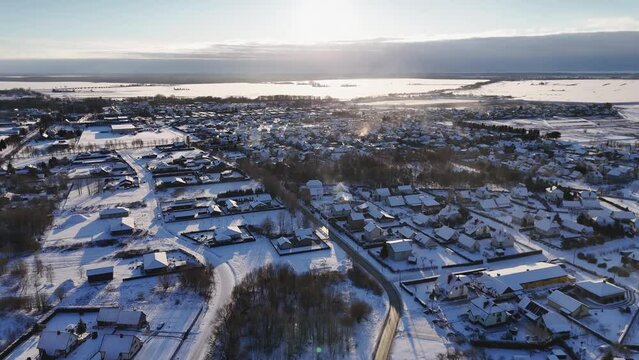 Cinematic drone shot of city of Silute housing society landscape in winter at sunset, Lithuania