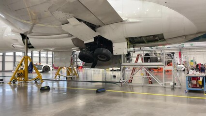 The landing gear of a large aircraft extend and retract into the fuselage.