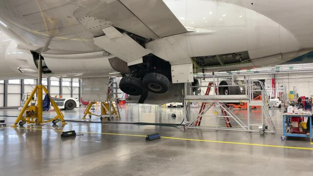 The landing gear of a large aircraft extend and retract into the fuselage.