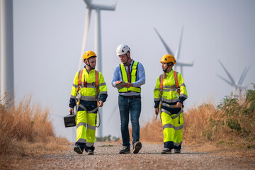 Engineer surveyor wearing uniform walking holding box inspection work in wind turbine farms...