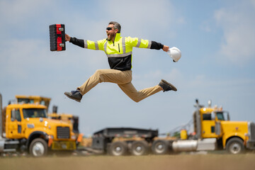 Hispanic builder excited jump and run on site construction. Excited builder construction worker in...