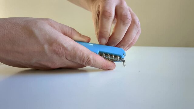 Man opening pocket knife, selecting right knife, close up