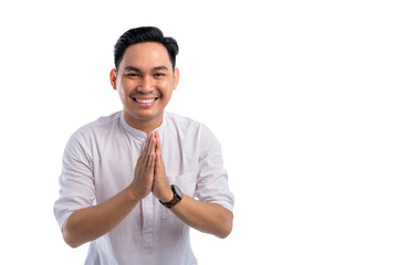 Happy Asian Muslim man gesturing Eid Mubarak greeting isolated on white background. Ramadan and Eid Fitr celebration concept