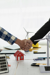 Architect and construction engineer holding hands while working for teamwork and cooperation concept after completing an agreement on construction site. Close-up pictures - obrazy, fototapety, plakaty