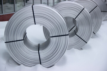A coil of aluminum wire, in the snow
