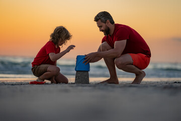 Father and kid son build sand castle at the summer beach, Kid and father building sandcastle....