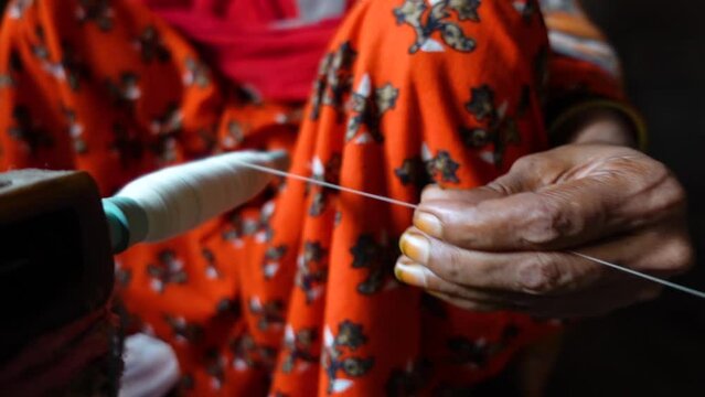 A woman's hand spinning yarn on a reel