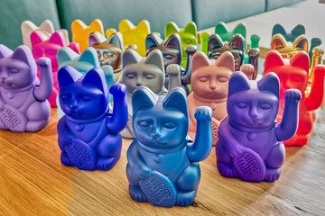 Collection of Japanese maneki cats of various colors on wooden table