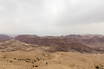 View from distance from high hill to famous gorge in which it is located thr Nabatean Kingdom of Petra in the Wadi Musa city in Jordan