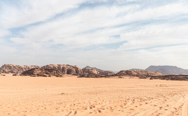 Fototapeta na wymiar Low ridges of the mountains in the endless red desert of the Wadi Rum near Amman in Jordan