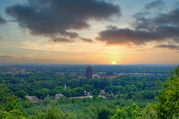 This tranquil image offers a sweeping view of a suburban landscape at sunset. The serene sun dips...