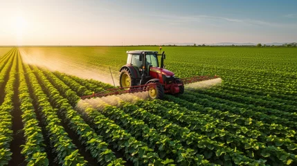 Gordijnen Tractor spraying pesticides fertilizer on soybean crops farm field © ND STOCK