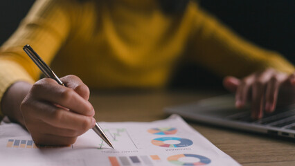 Close-up of businesswoman's hands checking company finances and earnings and budget with graph on...