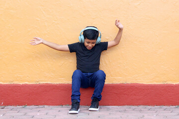 9-year-old dark-skinned Latino boy uses hearing aids that alter learning, memory and retention capacity, producing social isolation, hypocausia and tinnitus - obrazy, fototapety, plakaty