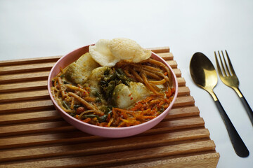 Lontong with curry soup accompanied by fried sweet potatoes chili sauce and noodles
