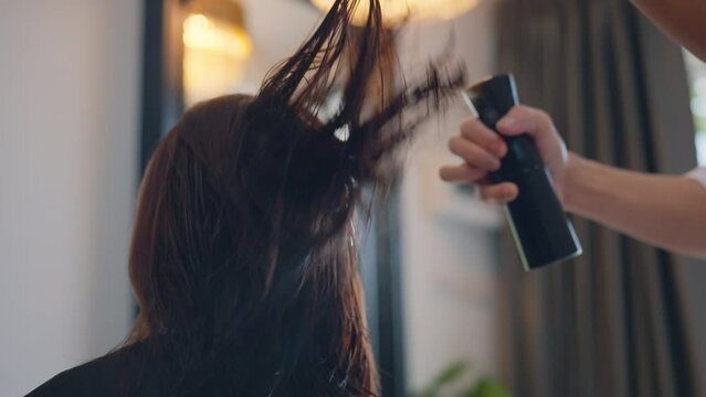 Hairdresser spraying female client's hair with water at salon, Local business, work, hairdressing, hair care and hairstyling, Hair care concept.