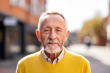 Portrait of an elderly man in a yellow sweater on the street