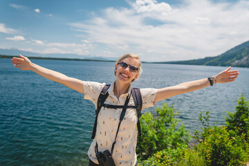 Woman smiling with arms outstretched at Jenny Lake in Grand Teton National Park