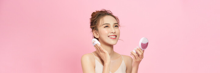 Portrait of beautiful asian woman applying powder puff at cheek makeup of cosmetic,