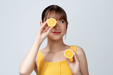 Young woman with cut lemon on white background. Vitamin rich food