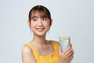 Young Asian lady enjoying healthy drink for beautiful skin and immunity on white