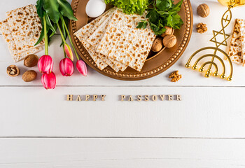 Festive background for the spring holiday of the Jewish Passover. Traditional foods, flowers, minor candlestick. Text of Happy Passover.