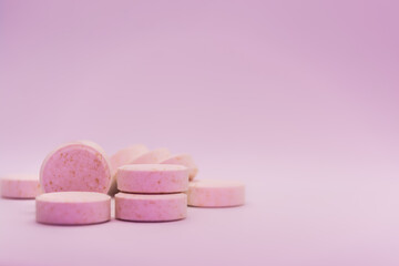 Close-up of pink pills on a pink pastel background. Selective focus. Theme is treatment of diseases, medicine and pharmaceuticals.