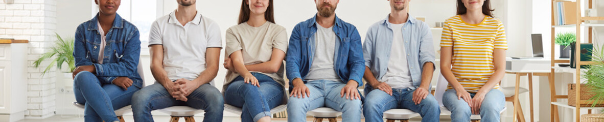 Cropped shot of multiethnic group of job applicants sitting in row. Close up photo of diverse young...