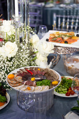 Elegant Cheese and Cold Cuts Platter with Garnishes on Decorated Table